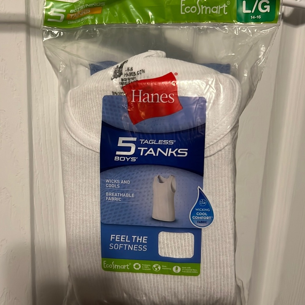 Brand new still in package Boys tagless white ribbed tank. Size large 14-16